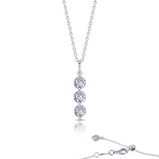 The Lafonn Three-Stone Pendant Necklace is a sterling silver piece that showcases a vertical pendant adorned with three round, sparkling simulated diamonds in a row. The chain includes a delicate clasp with an adjustable length and features a small round diamond accent near the clasp. The necklace is beautifully displayed on a reflective white surface.