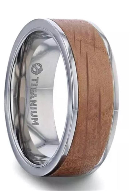 The Whiskey Barrel Inlaid Titanium with Flat Polished Edges Band by Thorsten features a wooden inlay running around the titanium band. The inner side boasts a polished finish and is engraved with the word "Titanium" next to an emblem.