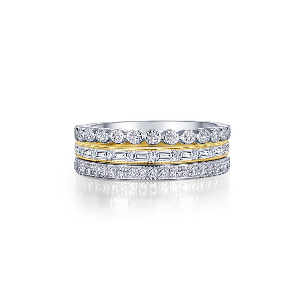 A close-up of the 3-Piece Eternity Ring Set by Lafonn reveals a stunning arrangement: a top band with round diamonds, a middle gold band adorned with baguette diamonds, and a bottom band featuring smaller round diamonds in a silver setting. The rings have a mesmerizing sparkling appearance.