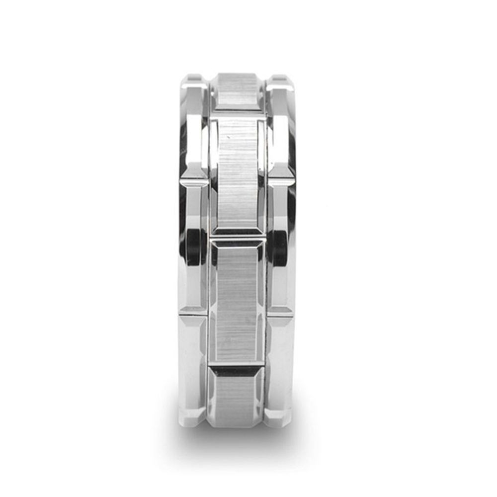 A close-up shot of the Thorsten WARWICK Beveled Tungsten Carbide Wedding Band, showcasing its geometric, rectangular design. This silver-toned ring features a brushed metal texture and alternating raised and recessed segments, creating a modern, industrial look against a plain white background.