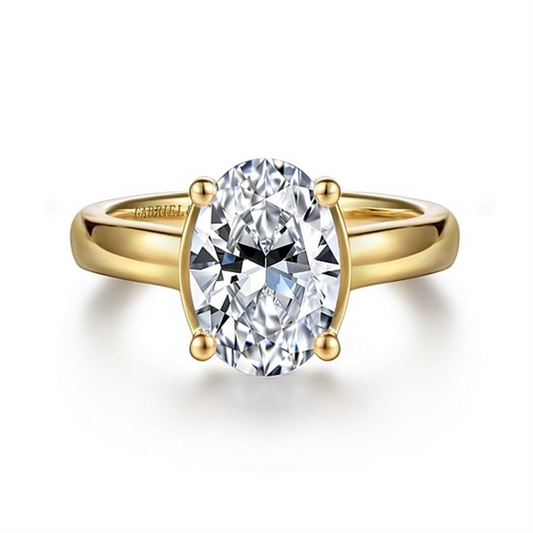 The Gabriel & Co 14K Yellow Gold Half Bezel Oval Diamond Engagement Ring (HEAD - 10.5X7) features a striking oval-cut diamond set in yellow gold, showcased against a white background.