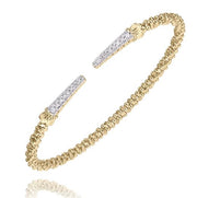 Introducing the "Diamonds and Gold Bracelet" by Alwand Vahan Jewelry—a delicate 14K Yellow Gold bangle adorned with an intricately beaded texture. The open ends of this elegant bracelet feature tapered tips encrusted with small white gemstones, adding a touch of sparkle. Designed to wrap around the wrist, this refined piece offers a sophisticated and timeless look.