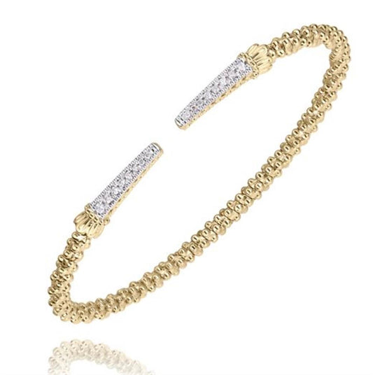 Introducing the "Diamonds and Gold Bracelet" by Alwand Vahan Jewelry—a delicate 14K Yellow Gold bangle adorned with an intricately beaded texture. The open ends of this elegant bracelet feature tapered tips encrusted with small white gemstones, adding a touch of sparkle. Designed to wrap around the wrist, this refined piece offers a sophisticated and timeless look.