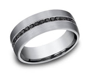 The 7.5mm Satin Tantalum 0.40cts Black Diamonds Channel Set Ring by Benchmark Rings features a sleek silver band with a central row lined with small black diamonds. The matte finish of the tantalum contrasts beautifully with the glossy stones, creating a modern and elegant look. This ring also boasts smooth, rounded edges and an unembellished interior for added comfort.