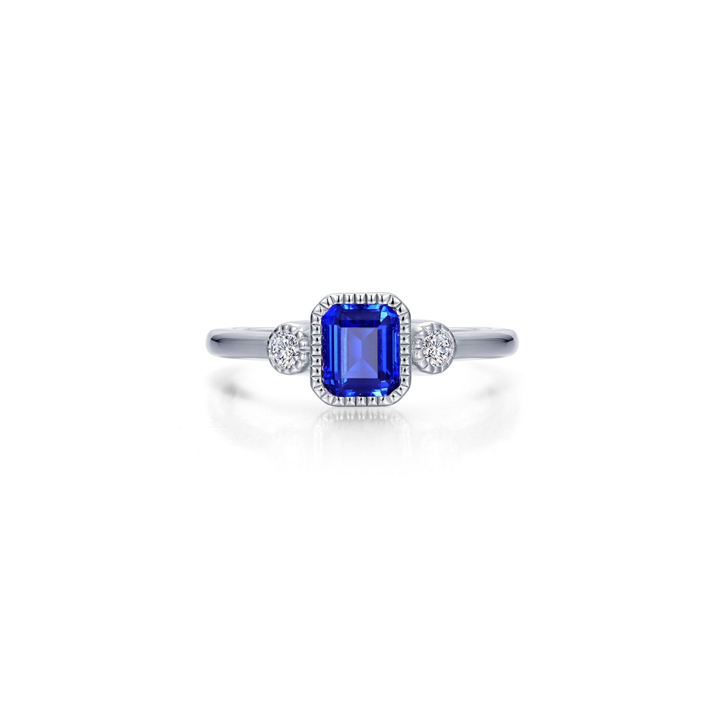 The Lafonn SIMULATED SAPPHIRE SEP STONE RING features a rectangular simulated sapphire at its center, accented by two clusters of clear stones on each side, all set on a sleek, polished silver band.