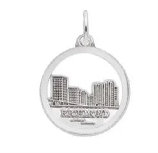 Introducing the Richmond Skyline Disc Charm from Rembrandt Charms. This exquisite sterling silver charm showcases an intricately detailed cityscape of Richmond, complete with tall buildings and a riverfront. The city name "RICHMOND" is beautifully engraved beneath the design, all encased within a circular frame that includes a loop for easy attachment to a chain.
