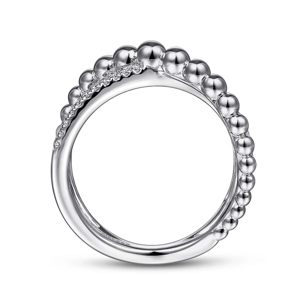 A close-up image of the 925 Sterling Silver White Sapphire Bujukan Criss Cross Ring by Gabriel & Co featuring a unique design with small, spherical beads along the top half, and accentuated with tiny diamonds on one side. The ring is polished, reflecting light off its shiny surface.