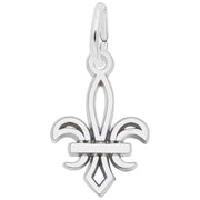 A Rembrandt Charms Petite Fleur De Lis Charm / Sterling Silver, showcasing smooth, polished surfaces and a small loop at its top for attaching to a chain or necklace. The emblem features symmetrical design elements and a clean, elegant appearance.
