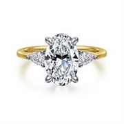 Gabriel & Co’s 14K yellow diamond engagement ring (SO:1961424) features an 11x7.2mm oval-cut center diamond with two side triangular diamonds on a simple gold band.