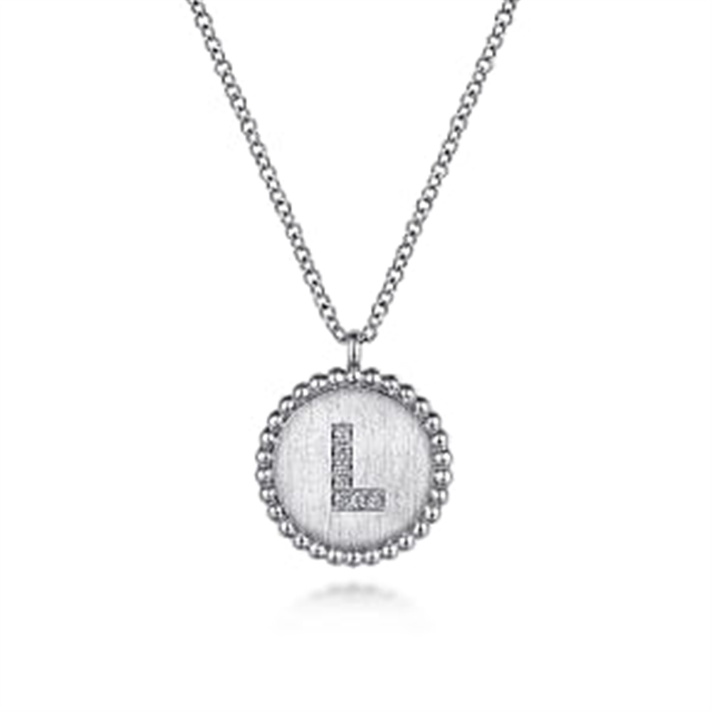 Discover the dazzling elegance of Gabriel & Co’s 925 Sterling Silver Diamond Bujukan Initial L Necklace. The silver necklace features a circular pendant with a textured surface and a capital "L" encrusted with small diamonds, all edged by an intricate beaded design.