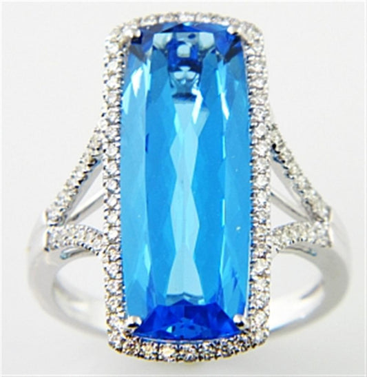 An exquisite ring from Bellarri's Silk Road Collection, the Blue Topaz and Diamond Ring D-0.40 BT-9.25 14KW S showcases a large, rectangular-cut Blue Topaz at its center, encircled by a halo of small, brilliant diamonds. The band features an intricate split design on each side, further embellished with additional small diamonds for a truly ornate finish.