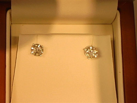A pair of Veer 14KW 4-prong / 1.5ctw screw back stud earrings are showcased in a jewelry box. The round-cut diamonds, set in 14KW, rest on a cream-colored cushion with the box interior softly illuminated.
