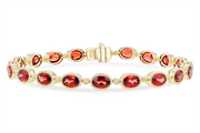 The Allison Kaufman Garnet and Diamond 14k Yellow Gold Bracelet features oval-shaped red garnets elegantly set in gold bezels, accented with small diamonds. It has a clasp closure that secures the sparkling, faceted gemstones beautifully.