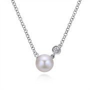 Part of the Bujukan Collection, this 925 Sterling Silver Bujukan Pearl Pendant Necklace by Gabriel & Co., Serial No: S1660, features a single white pearl pendant and a small clear gemstone accent. The pearl and gemstone are connected along the chain, creating an elegant and minimalist design.