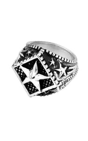 The Diamond Star Silver Ring by King Baby is a handcrafted .925 sterling silver ring, featuring an intricate design with a prominent star at the center, surrounded by smaller stars and textured details on a black background. The band is meticulously adorned with detailed patterns, showcasing its exceptional elegance and craftsmanship. Handmade in the USA, this piece radiates elegance and quality artistry.