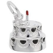 The Rembrandt Charms Cake Charm, crafted from sterling silver, features a two-tiered cake adorned with a small red candle on top. Intricately decorated with scalloped designs and equipped with a loop for attaching to a bracelet or necklace, this charm is perfect for commemorating special celebrations.