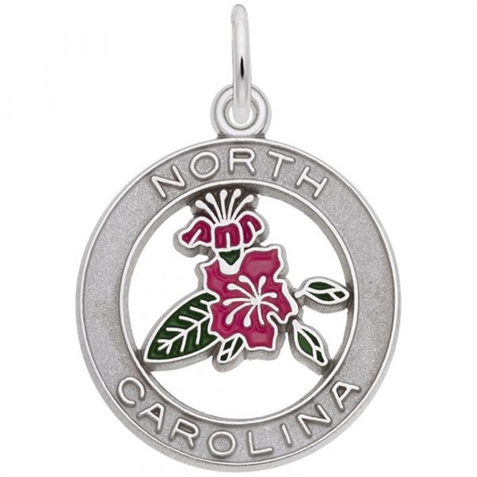 The North Carolina Azalea Charm by Rembrandt Charms is a round, sterling silver charm displaying a ring that reads "North Carolina." Inside the ring, there is an enamel design of a pink dogwood flower with green leaves, inspired by the North Carolina Azalea. A small loop is attached to the top for easy hanging.