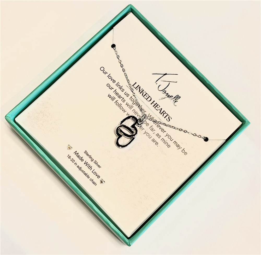 The Linked Hearts Silver Necklace by T Jazelle is displayed in a turquoise gift box, featuring two heart pendants above a heartfelt love message, with the brand name "T Jazelle" elegantly printed on top.