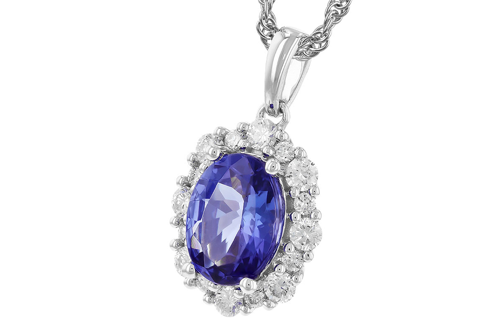 The Tanzanite and Diamonds 14K White Gold Necklace by Allison Kaufman features a stunning 1.02-carat oval tanzanite pendant, accented with a cluster of glittering clear stones, all on a sleek 14K white gold chain. The deep blue hues of the gemstone are striking against the elegant white setting.