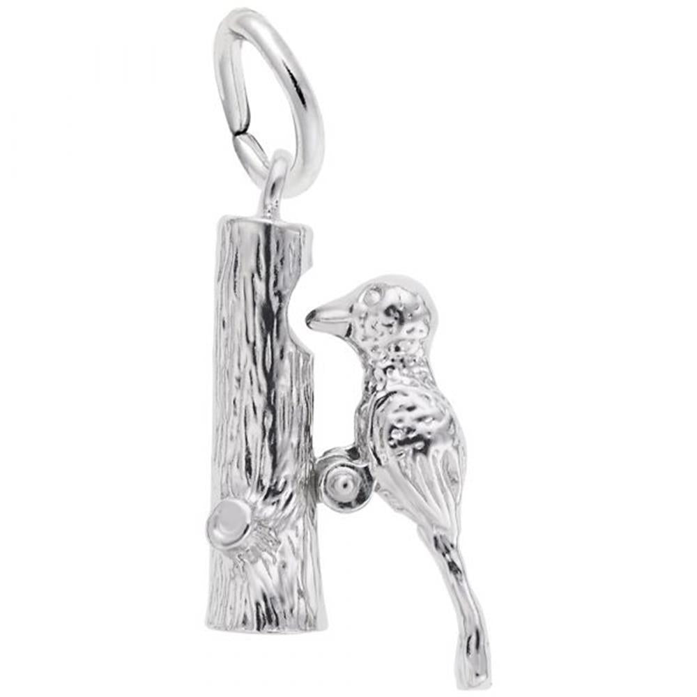 The Rembrandt Charms Woodpecker Charm / Sterling Silver features a detailed woodpecker perched on the side of a vertical tree trunk. This sterling silver pendant includes a loop at the top for attaching to a chain or bracelet, and showcases intricate texturing on both the bird and the tree trunk.