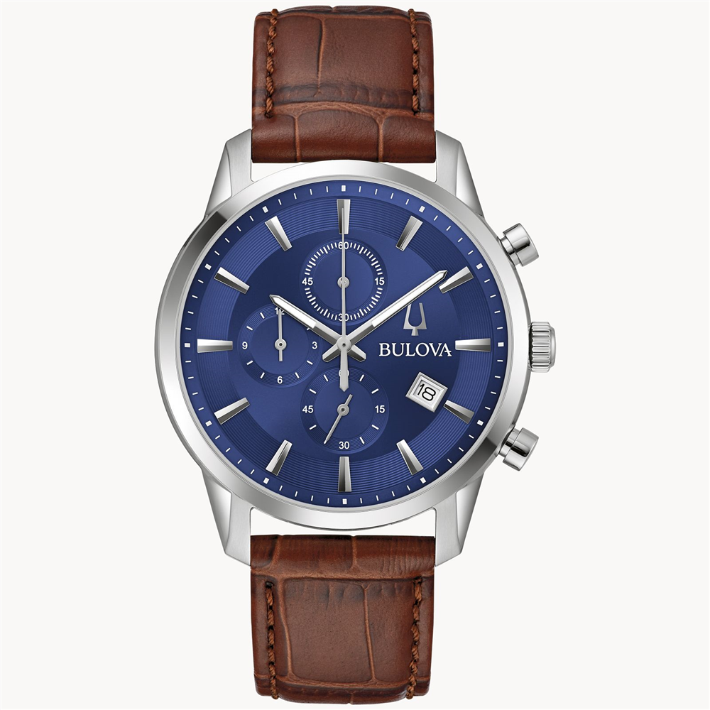 The Bulova Watch Company's 6 Hand Men's Sutton Watch features an analog display with a stainless-steel case, a blue dial, and a brown crocodile leather grain strap. It includes three subdials, a date window at 4 o'clock, silver hour markers, and luminescent hands. This watch boasts a classic, elegant design.