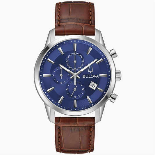 The Bulova Watch Company's 6 Hand Men's Sutton Watch features an analog display with a stainless-steel case, a blue dial, and a brown crocodile leather grain strap. It includes three subdials, a date window at 4 o'clock, silver hour markers, and luminescent hands. This watch boasts a classic, elegant design.