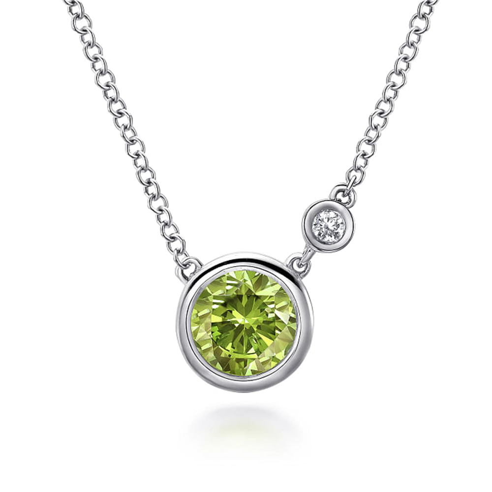 Experience the elegance of the Gabriel & Co 925 Sterling Silver Peridot and Diamond Pendant Necklace. This exquisite piece showcases a round, green Peridot gemstone set in sterling silver, complemented by a small, clear diamond above it. The design is minimalist yet sophisticated, highlighting the vibrant stones beautifully.
