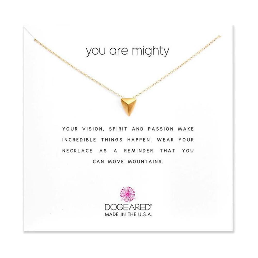 A delicate gold necklace featuring an 18" chain and a small, pointed pendant is showcased against a white background, accompanied by the text "You Are Mighty." Below the necklace, a heartfelt message reads: "Your vision, spirit and passion make incredible things happen. Wear your You Are Mighty / GP-SS / 18" necklace as a reminder that you can move mountains." The brand "Dogeared" is noted along with "Made in the USA".