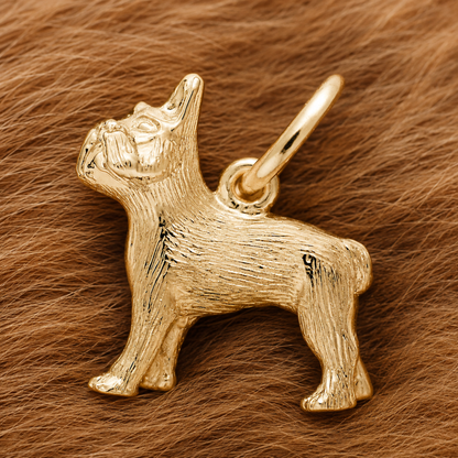 A French Bulldog Dog Charm—gold plated by Rembrandt Charms—rests atop a soft, brown, fur-like surface, making an elegant pet keepsake and a thoughtful gift for any dog lover.