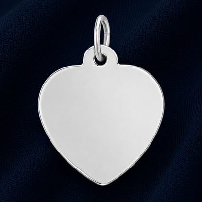 A gold-plated Medium Heart – 35 Series Charm by Rembrandt Charms, featuring a sleek heart shape with a small loop at the top and displayed on a dark blue textured fabric background—ideal as an engravable jewelry piece or a meaningful personalized gift.