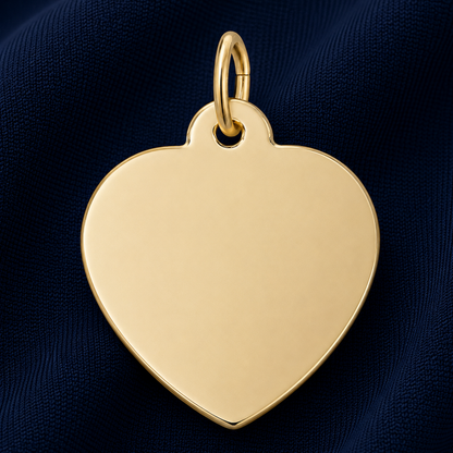 A Rembrandt Charms Medium Heart – 35 Series Charm in gold plate, featuring a smooth, unengraved surface—ideal as engravable jewelry or a meaningful personalized gift—displayed against dark blue textured fabric.