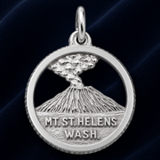 The Mount St. Helens Disc Charm by Rembrandt Charms features a sterling silver depiction of the iconic volcano erupting, with “MT. ST. HELENS WASH.” engraved beneath the scene. Set against a dark blue fabric background, this charm makes an ideal Pacific Northwest keepsake.