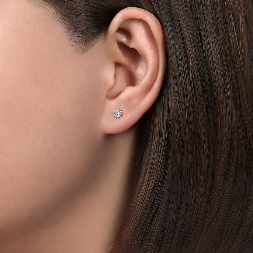 Close-up of a woman’s ear with straight brown hair, wearing Gabriel & Co 14K White Gold Cluster Diamond Flower Stud Earrings.