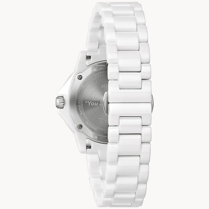 A Bulova Marc Anthony Marine Star White Dial Women's Watch by Bulova Watch Company is shown from the back, displaying a silver engraved case back, left-side crown, and a white ceramic link-style bracelet.