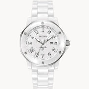 The Bulova Marc Anthony Marine Star White Dial Women's Watch by Bulova Watch Company features a metallic bezel, Roman numerals, diamond hour markers, date window, white ceramic bracelet, and a modern design.