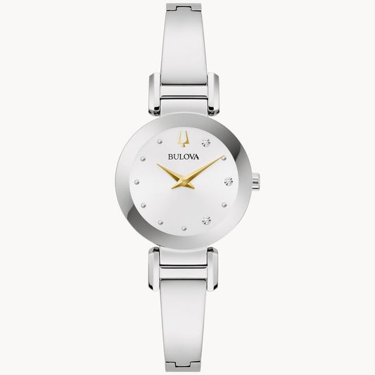 The Marc Anthony "Valió la Pena" Women's Watch with Diamonds by Bulova features a sleek silver design with a minimalist round dial accented by sparkling diamonds. The dial includes small, diamond-like hour markers, a gold-toned logo at the 12 o'clock position, and gold-toned hour and minute hands. The polished silver metal bracelet adds the perfect finishing touch to this elegant timepiece.