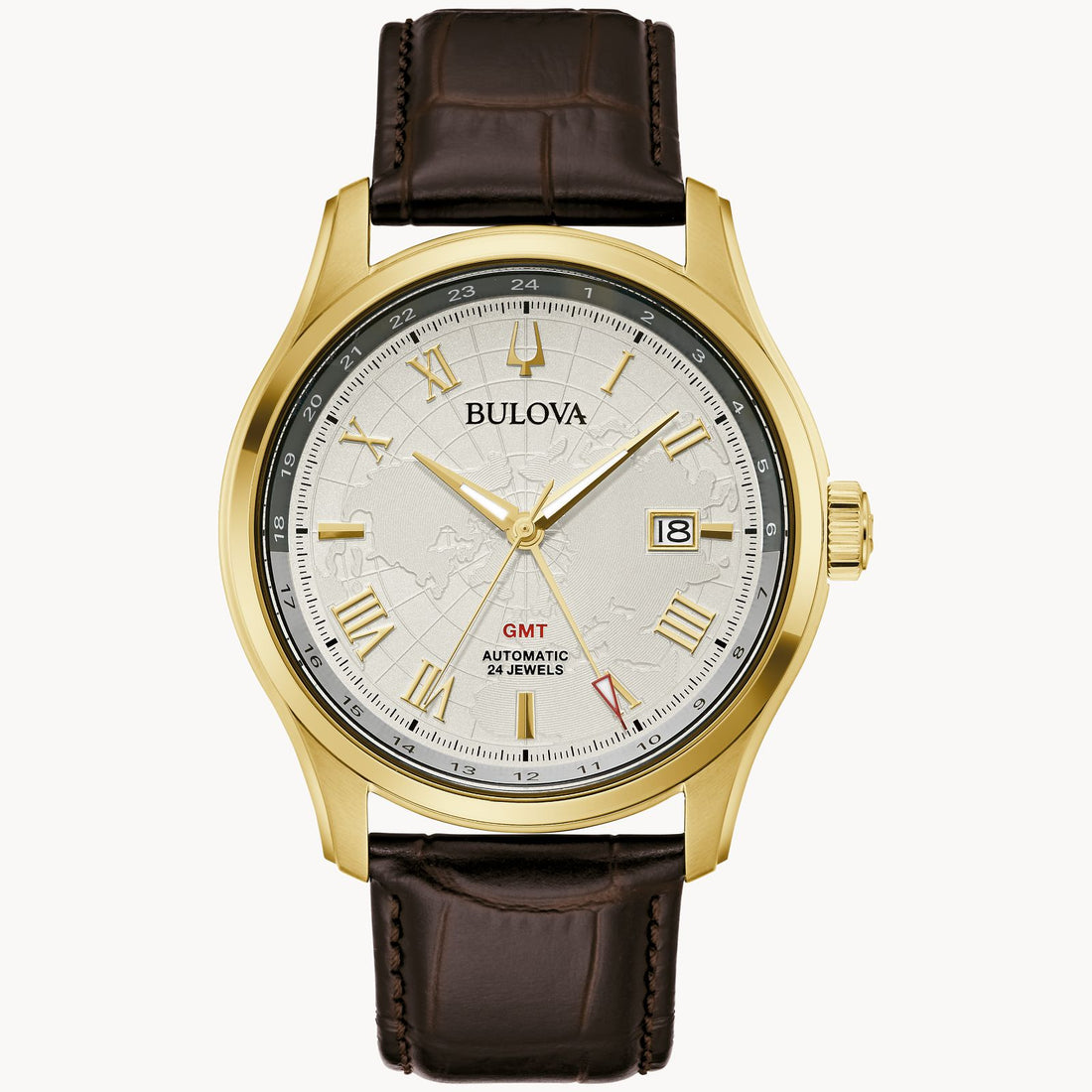 The Bulova Wilton Automatic Watch by Bulova Watch Company features a gold-tone stainless steel case, brown leather strap, silver dial with Roman numerals, date at 3 o’clock, red GMT hand, and a subtle world map design.