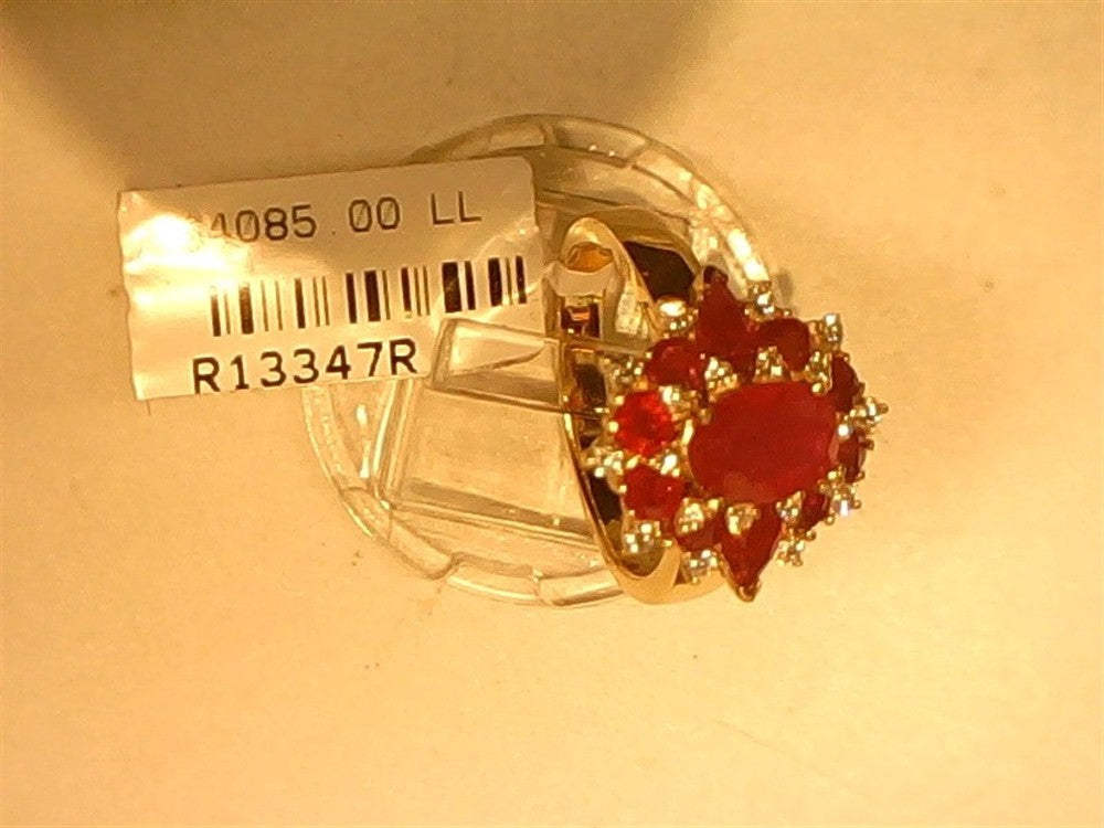 The Ryan Gems Diamond and Ruby (Royal) Ring in 14k yellow gold, size 6.75, showcases an oval red gemstone with smaller red stones and white accents, displayed on a stand with a tag reading "4085.00 LL" and "R13347R.