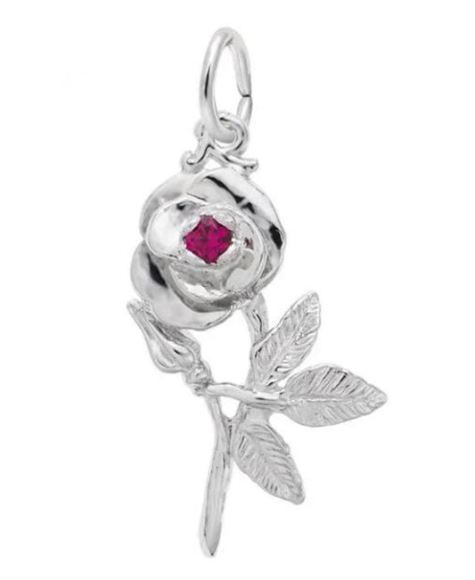 The Rembrandt Charms "Rose with Stone Charm" is a sterling silver pendant featuring a detailed rose with leaves and stem, accented by a small red gemstone at the center of the flower. It includes a loop at the top for easy attachment to a necklace or bracelet.
