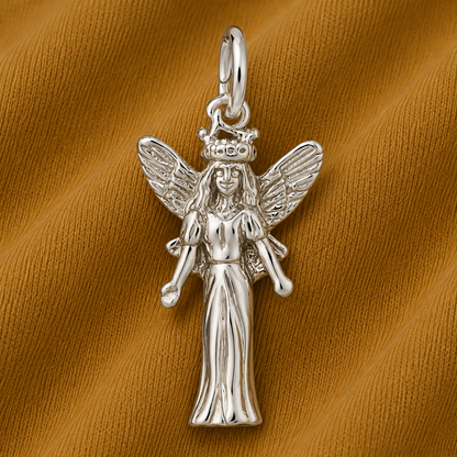 The Fairy—sterling silver charm by Rembrandt Charms features exquisite detailing and is beautifully displayed on a textured, golden-brown fabric background, making it an enchanting piece of whimsical jewelry.