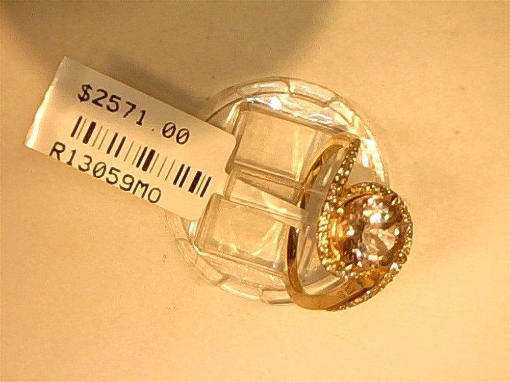 A Ryan Gems Diamond and round Morganite ring in 14k yellow gold, size 6.75, with sparkling accent stones is displayed on a stand. The price tag shows "$2571.00" and code "R13059MO".