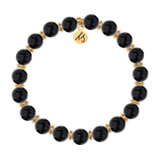The T Jazelle Gold Empowered Elegance Collection- Onyx Gemstone Bracelet features alternating shiny black onyx beads, gold spacers, and a round gold charm engraved with "15.