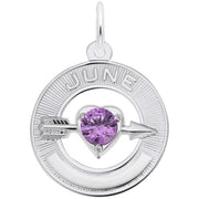 The Rembrandt Charms June Love Birthstone Charm, crafted from sterling silver, showcases a circular pendant with "JUNE" inscribed at the top. It features an alexandrite-colored stone in a heart setting, intersected by a silver arrow. This charm has a smooth metallic finish and includes a loop at the top for attaching to a chain.