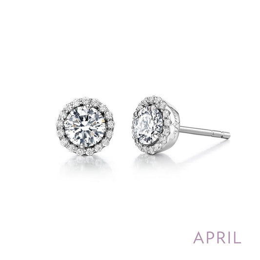 A pair of April Birthstone Earrings by Lafonn, featuring silver halo studs with round-cut simulated diamonds surrounded by smaller diamonds. The earrings are displayed side-by-side, with one facing forward and the other showing the side and post. The word "APRIL" is written in purple in the bottom right corner, emphasizing Lafonn birthstone jewelry.