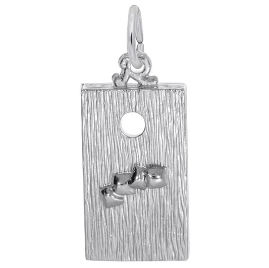 A sterling silver rectangular pendant from Rembrandt Charms, inspired by the Corn Hole Game Charm, showcases a textured surface with a small hole near the top and three small raised shapes clustered at the bottom, complete with an attached loop for a chain.