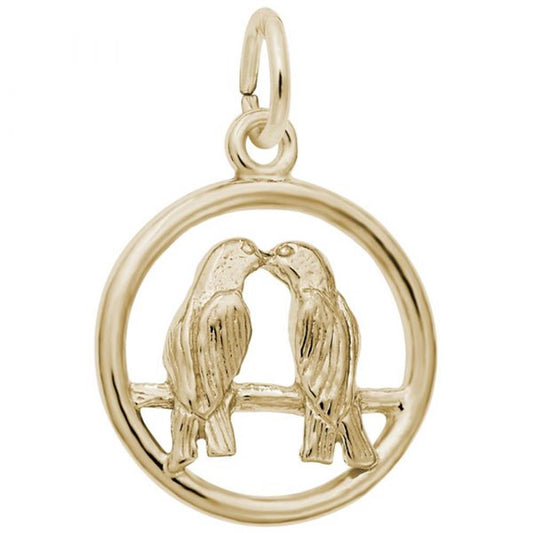 The Love Birds Charm by Rembrandt Charms is a gold-plated sterling silver pendant featuring two love birds facing each other and touching beaks while perched on a branch. The birds and branch are enclosed within a circular frame, creating a charming symbol of affection.