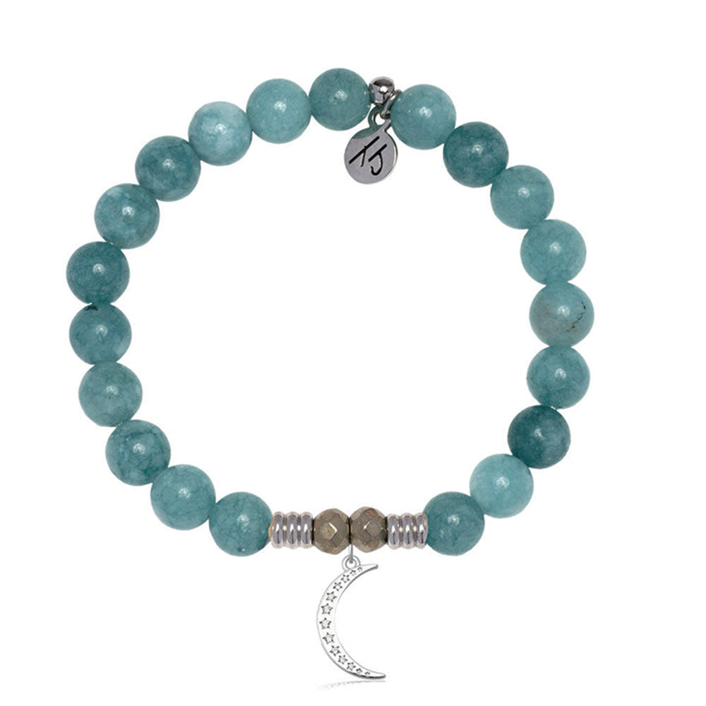 The T Jazelle Mountain Blue Jade Gemstone Bracelet features blue jade stones, silver accents, a crescent moon charm with star detail, and a tag engraved with a symbol hanging from the band.