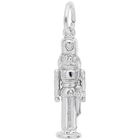 The Nutcracker Charm by Rembrandt Charms is crafted from sterling silver, showcasing intricate design elements such as a tall hat, distinct facial features, a belted uniform, and elongated legs. This charm also features a loop at the top for easy attachment to bracelets or necklaces.