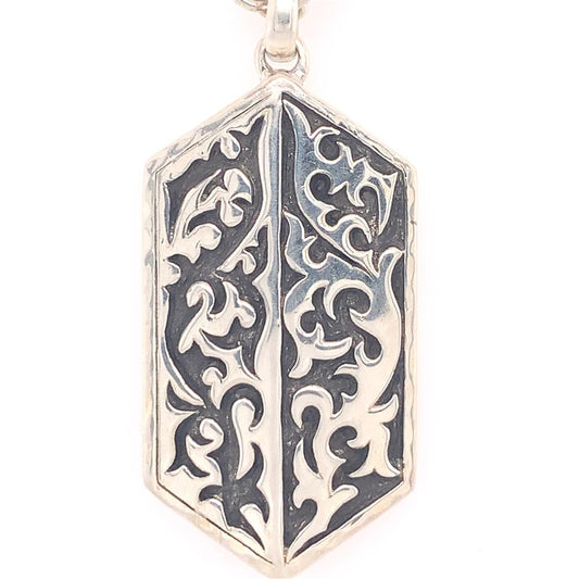 Introducing the Lois Hill Gents Sterling Silver Necklace, showcasing a hexagonal pendant with an intricate raised floral design set against a black background. The sterling silver pendant comes with a small loop at the top for easy threading onto a chain.
