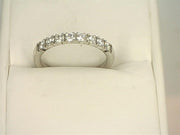 A stunning 14K White Gold .4800ctw Round Cut Diamond Anniversary Band by Benchmark Rings, adorned with multiple small lab-grown diamonds along the top half, gracefully displayed in an open white jewelry box.
